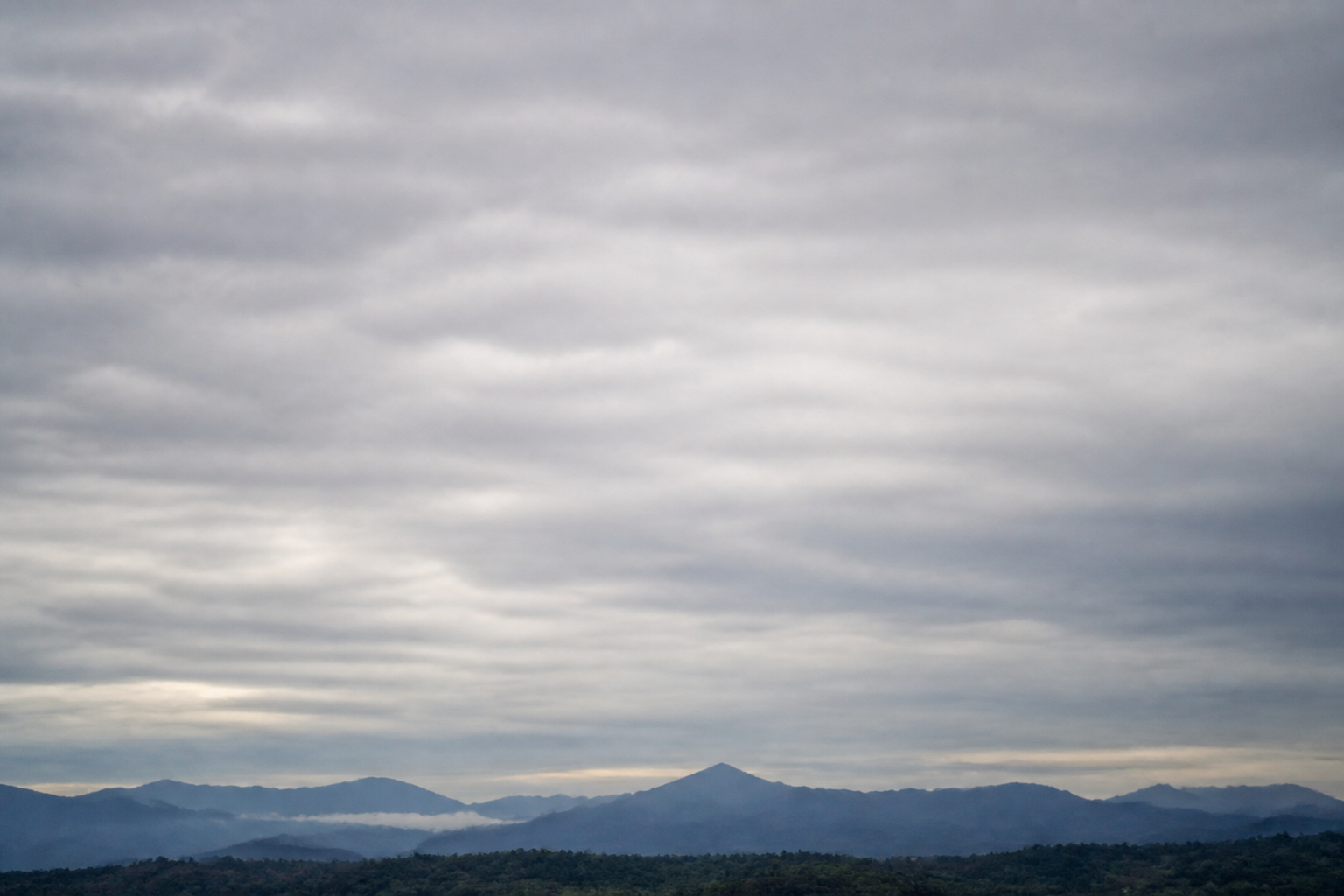 Nappe grise et uniforme d'altostratus derrière laquelle le soleil apparaît comme derrière un verre dépoli