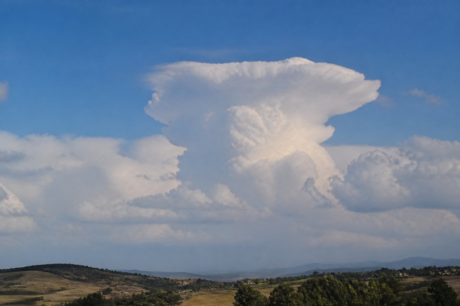 Cumulonimbus dont le sommet s'étale en enclume fibreuse au-dessus d'une base sombre et pluvieuse